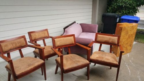 Four dining chairs and a sofa staged for pickup