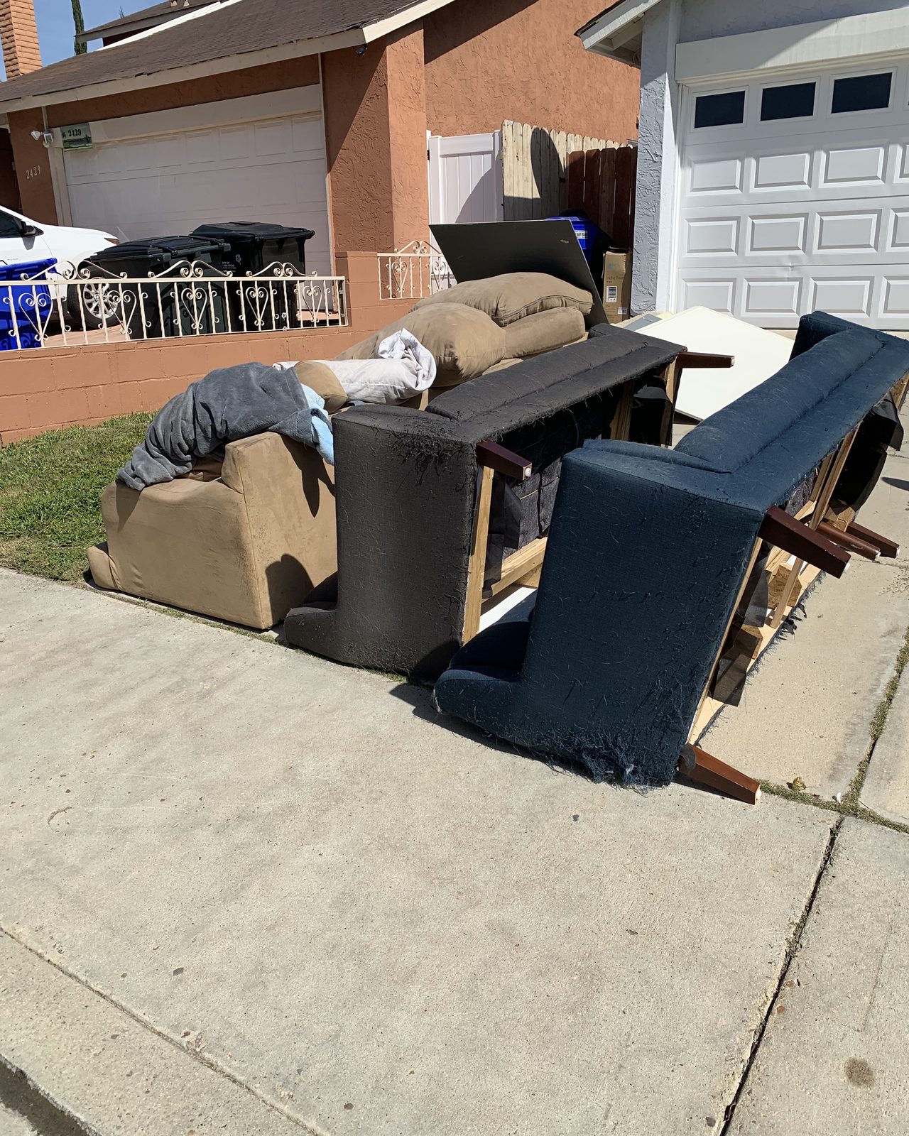 Sofas and chairs staged on a San Diego sidewalk for haul-away